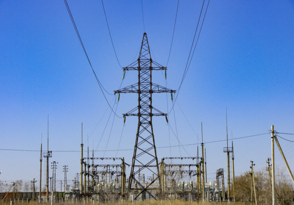 High power voltage electricity equipment. Electricity transmission pylon opposite the blue sky.